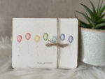 Birthday greeting card featuring a rainbow of watercolour balloons