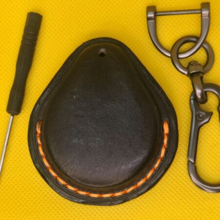 Back view of Black a vegetable tanned leather key fob case for Harley Davidson motorcycles with orange stitching and a stainless steel, lobster clasp keychain and screwdriver.