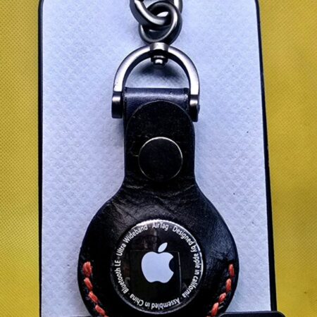 Black leather apple air tag with red stitching hanging from a lobster clasp keychain,