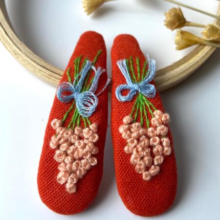 Berry Bow hand-embroidered floral hair clip with berry-red blossoms on a soft felt base