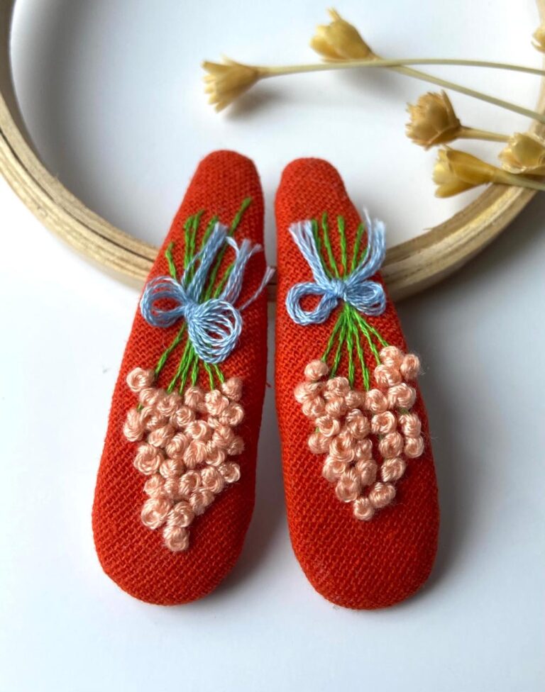 Berry Bow hand-embroidered floral hair clip with berry-red blossoms on a soft felt base