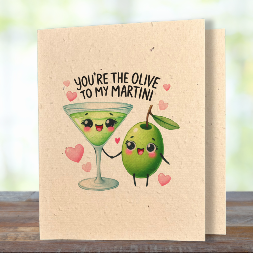 plantable greeting card, natural coloured paper, embedded with wildflower seeds, an image in kawaii style of an olive and a martini drink holding hands, the sentiment reads, you're the olive to my martini