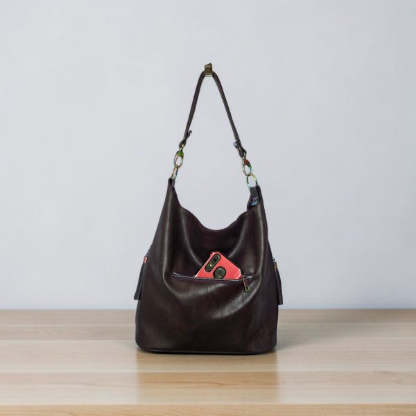 A Slouchy multi pockets eggplant color bag with iridescent hardware and decorative zipper tassels