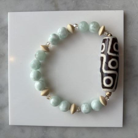 Green angelite bracelet with beige wood beads and a Tibetan agate gemstone centerpiece.